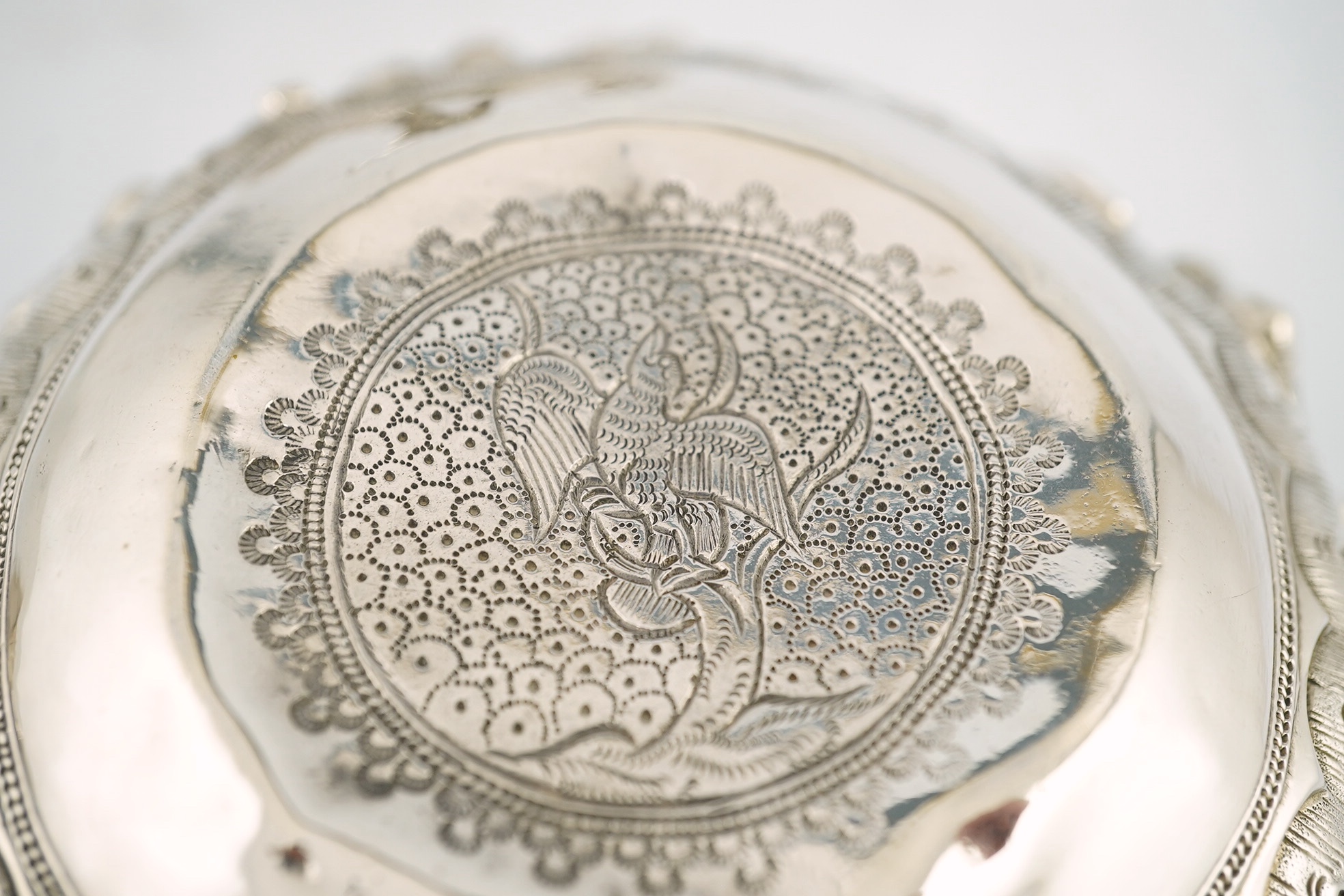 A pair of Burmese white metal bowls, embossed with figures, 12cm diameter, 220 and 224g and a plainer bowl, 110g. Condition – fair